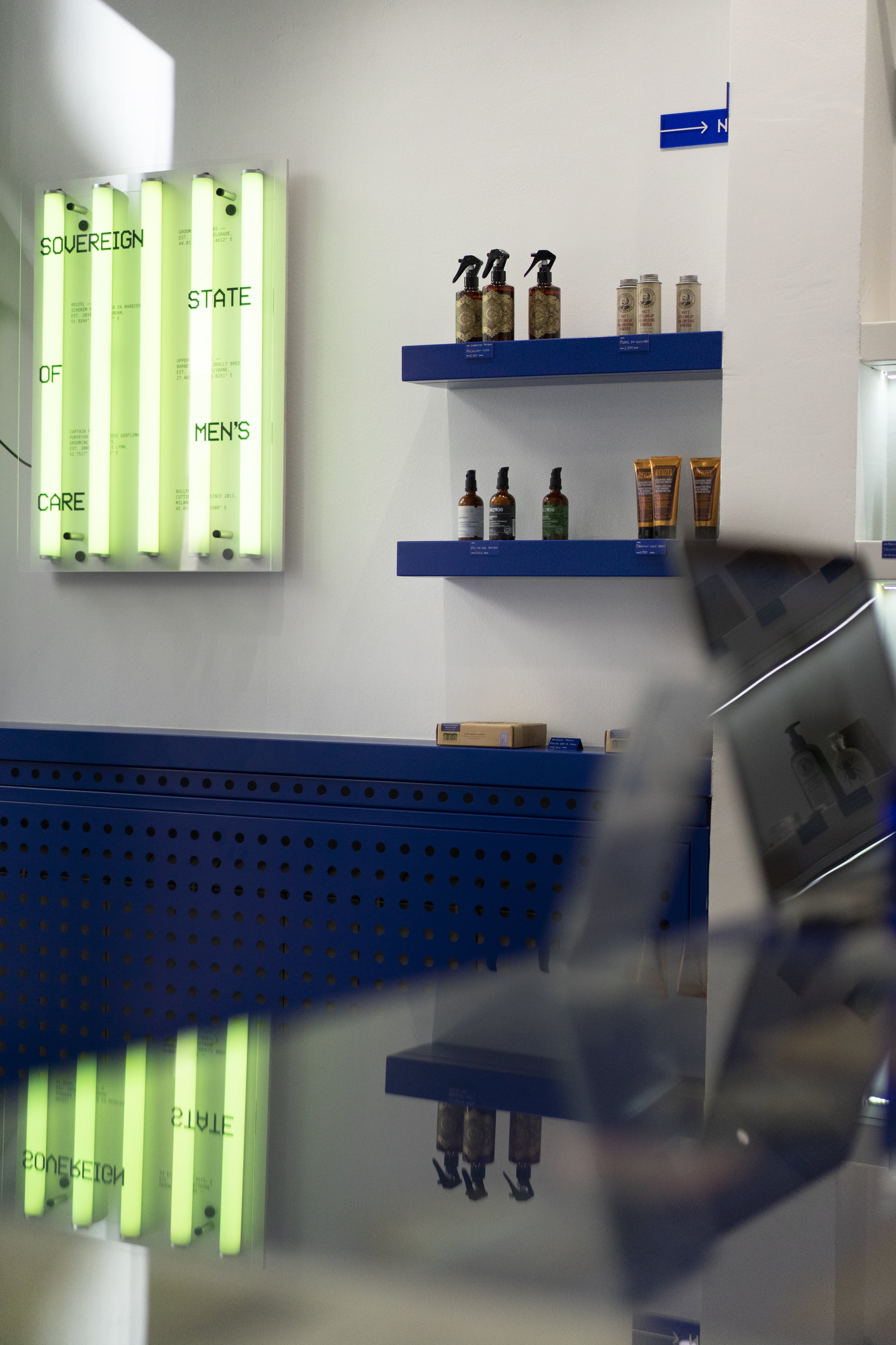 Sovereign State of Men's Care — the neon manifesto beside Klein-blue shelves of product