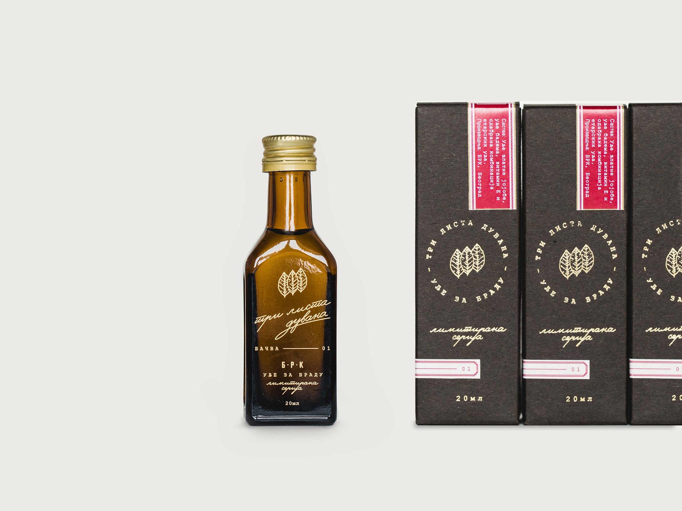 Три листа дувана limited-series beard oil — amber bottle with gold script beside black boxes with gold foil roundels and crimson seals