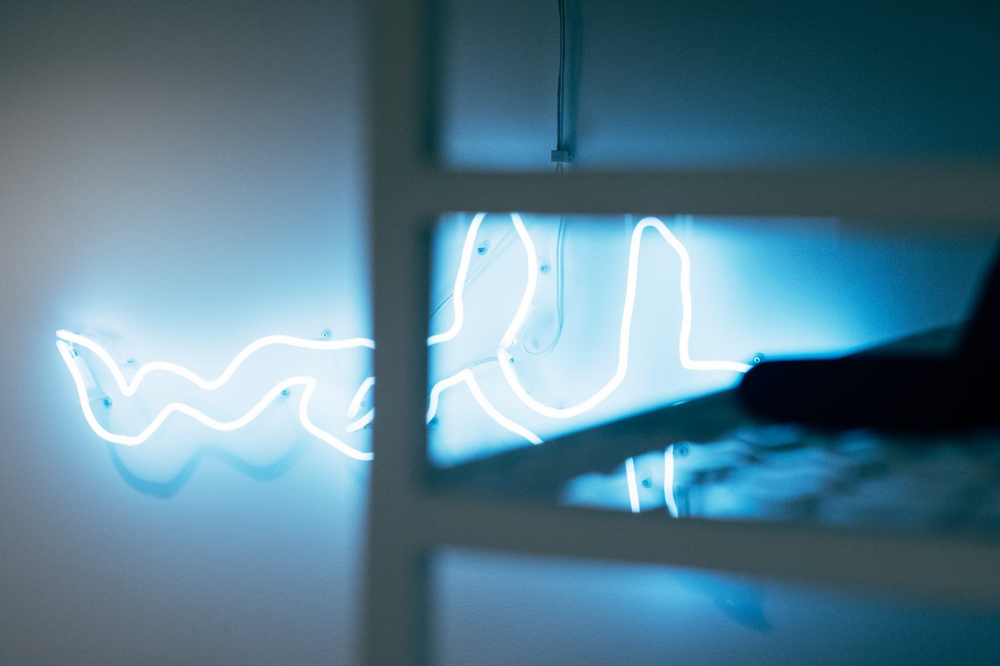 The neon glowing blue through the white grid shelving