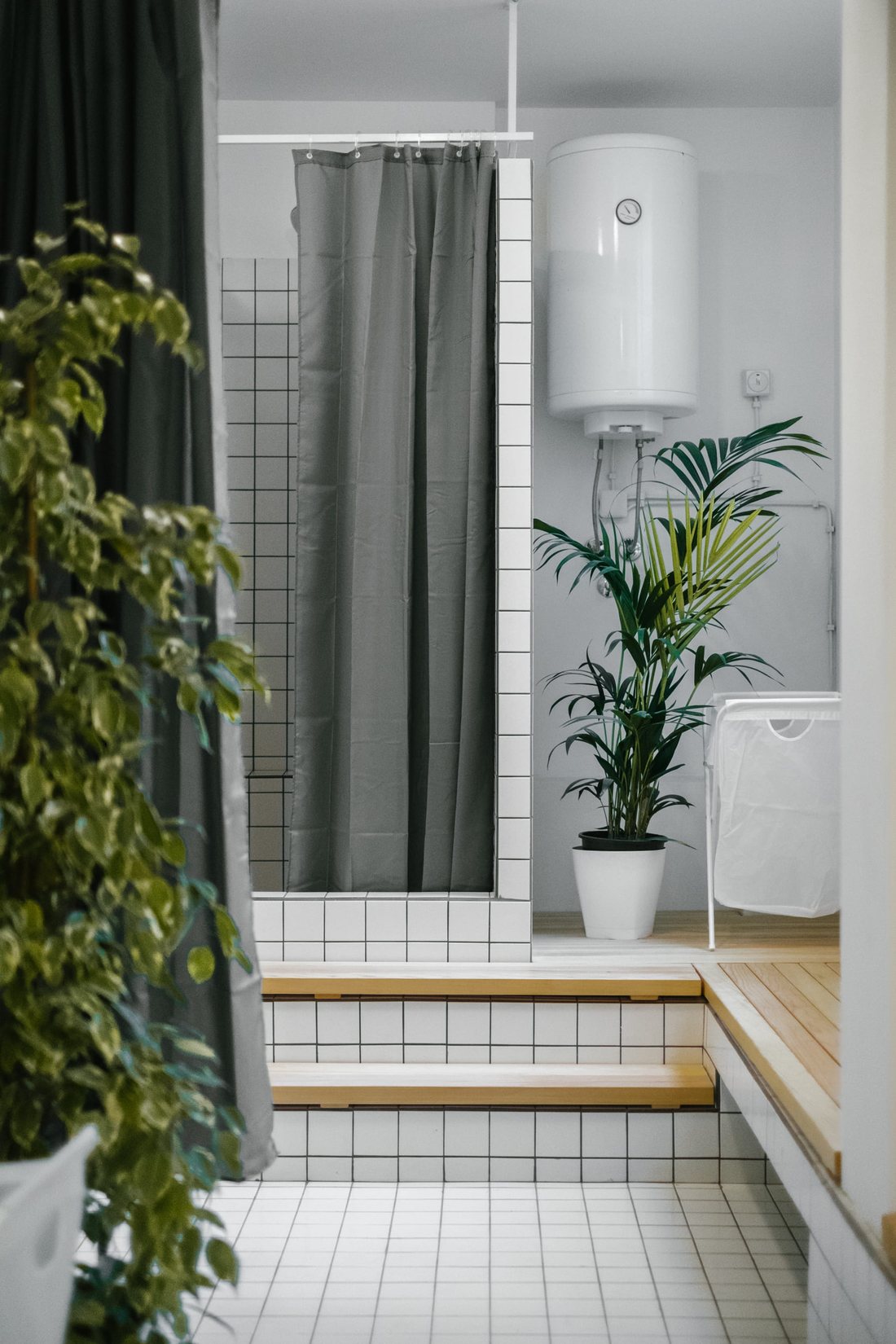 Changing area — white tile, grey curtain, cedar deck steps and plants
